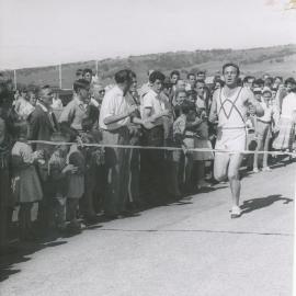 Tommy Brooks crossing the finishing line of the first "Elizabeth Mile"